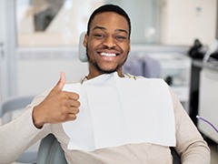 Man smiling while giving thumbs up in treatment chair