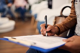 Woman filling out dental insurance form in lobby